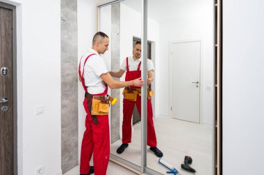 Mobilya montajı. Profesyonel işçi, yeni evin oturma odasına gardırop kuruyor. Yüksek kalite fotoğraf