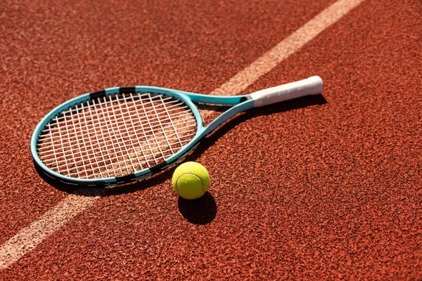Play tennis. Close-up of tennis racket and tennis ball laying on the court . High quality photo