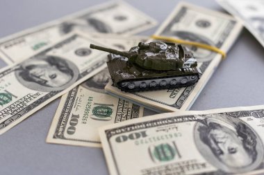 Dolar banknotlarının arka planında oyuncak tankı var. Yüksek kalite fotoğraf
