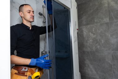 Tesisatçı banyoya duş kabini kuruyor. Yüksek kalite fotoğraf