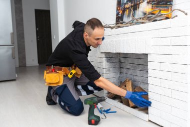 Şömine beyaz tuğla duvara monte ediliyor. Yüksek kalite fotoğraf