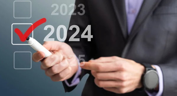 stock image man hand touching on 2024 calender year button on digital virtual screen blur background. High quality photo