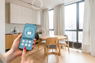 Akıllı ev arayüzü çift pozlama ile bulanık mutfakta akıllı telefon tutan kadın eli. Otomasyon kavramı