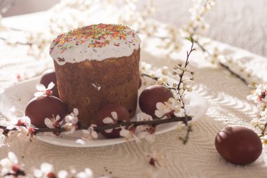 Paskalya kompozisyonu. Çiçekli bir kayısı dalı, boyanmış yumurtalar ve şeker parçacıklarıyla süslenmiş paskalya pastası..