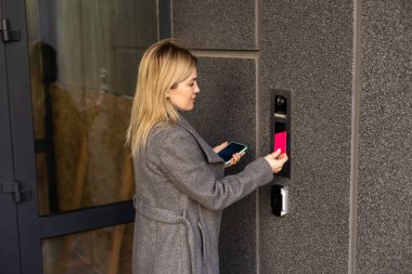 Orta yaşlı kadın dahili telefonun düğmesine basıyor.