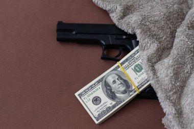 Bir yığın Amerikan doları ve siyah bir tabanca. Yukarıdan görüldü. Yüksek kalite fotoğraf