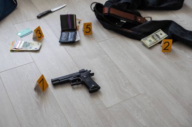 Olay yeri inceleme konsepti, tabanca ve mermi kovanına karşı apartmanın zeminindeki sarı işaret. Yüksek kalite fotoğraf