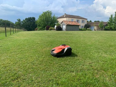 Robotic lawn mower on grass, side view. High quality photo clipart