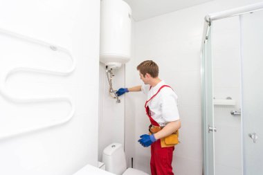 Profesyonel tesisatçı kazan ve boruları kontrol ediyor.