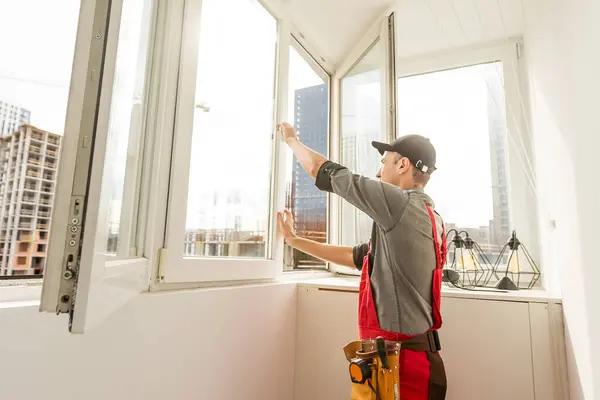 Worker man installs plastic windows and doors with double-glazed white. High quality photo