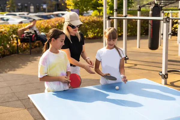 Family playing table tennis in the summer outdoors. High quality photo