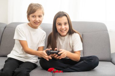 Evde video oyunu oynayan iki kız kardeş. Mutlu çocuk, tasasız çocukluk konsepti. Yüksek kalite fotoğraf