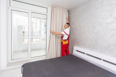 Üniformalı işçiler pencere perdelerini içeri asıyor. Yüksek kalite fotoğraf