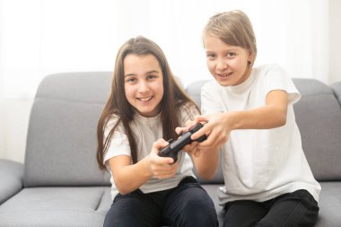 Evde video oyunu oynayan iki kız kardeş. Mutlu çocuk, tasasız çocukluk konsepti. Yüksek kalite fotoğraf