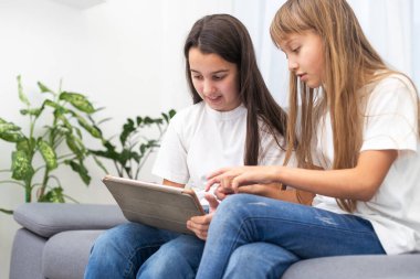 Evdeki kanepede dijital tablet kullanan şok olmuş kardeşler. Yüksek kalite fotoğraf