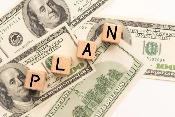 Sözcükler, dolar banknotlarından güzel bir arka plandaki tahta bloklardaki planlar. İş için. Yüksek kalite fotoğraf