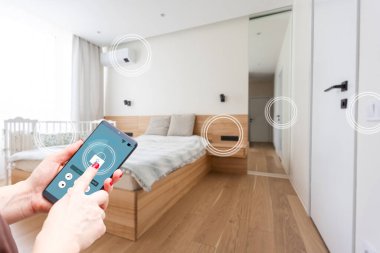 Akıllı ev, ev otomasyonu, uygulama simgeli aygıt. Kadın akıllı telefonunu akıllı güvenlik uygulaması ile evinin kapısını açmak için kullanıyor.