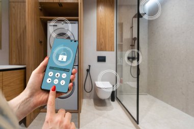 Akıllı ev, ev otomasyonu, uygulama simgeli aygıt. Kadın akıllı telefonunu akıllı güvenlik uygulaması ile evinin kapısını açmak için kullanıyor.