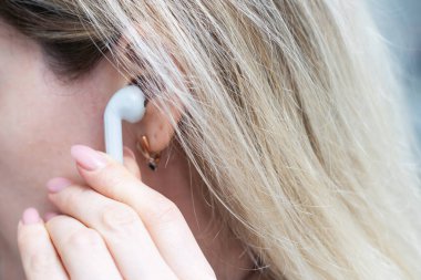 El ele tutuşan gri kablosuz kulaklıklar beyaz arka planda izole edilmiş. Yüksek kalite fotoğraf