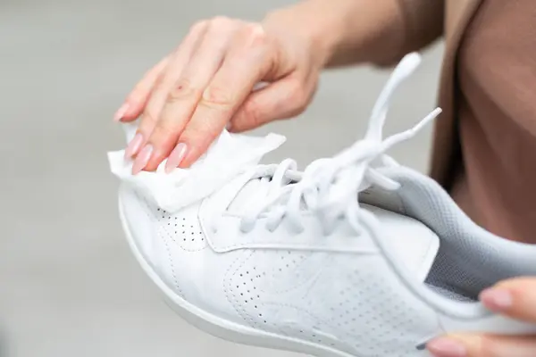 Cleaning white sneaker with cloth. High quality photo