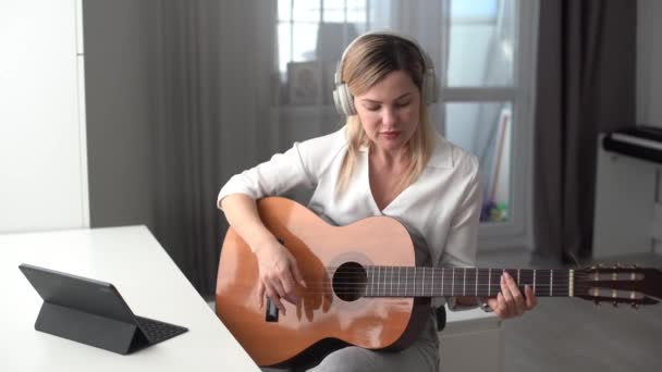 기타를 연주하고 튜토리얼을 녹음하는 Vlogger 블로거는 노래와 온라인 수업을 가르치는 — 비디오