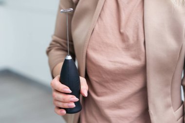 El bir cappuccino mikseri tutuyor. Kapatın. Beyaz bir arka planda izole edilmiş. Yüksek kalite fotoğraf