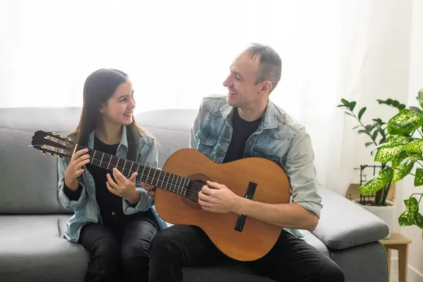 Happy family Father and daughter playing guitar. Fathers day. High quality photo