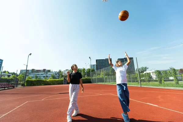 Concept of sports, hobbies and healthy lifestyle. Young people playing basketball on playground outdoors. High quality photo