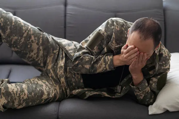 man in military clothes sleeping on the couch. High quality photo
