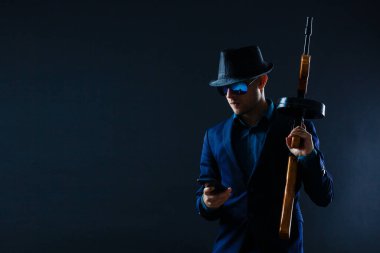 businessman in sunglasses and with a machine gun