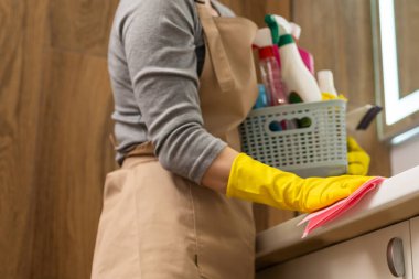 Hafta sonu ödevi. Genç ve güzel bir kadın evdeki rahat oturma odasını temizliyor. Parlak bir odada, ev kıyafetleri ve lastik eldivenler içinde güzel bir kadın.