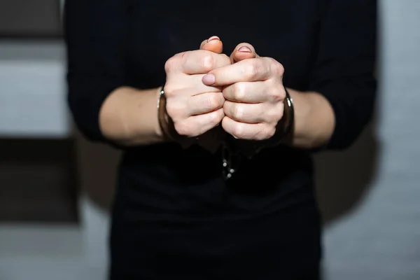 prisoner woman, prisoners hands are handcuffed behind her back. High quality photo