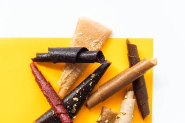 meyve ruloları portakal, mango, muz sarı arka planda yakın plan.