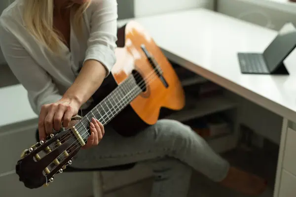woman holding a guitar with her hands. High quality photo