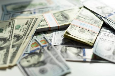 Arkaplan olarak 100 dolar. Birçok Amerikan doları yavaşça masaya düşüyor. Adam yeşil Amerikan parası saçıyor. Amerikan finans sistemi. Yüksek kalite fotoğraf