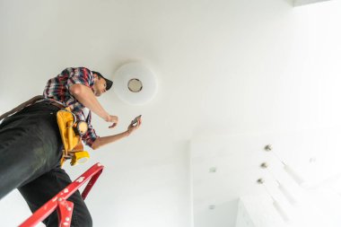 Müteahhit Elektrikçi. Lambayı tamir ediyorum. Yüksek kalite fotoğraf