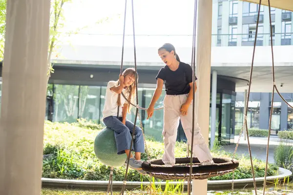 Genç bir kız, sıcak bir günde oyun parkında kutup gezintisinin tadını çıkarıyor. Yüksek kalite fotoğraf