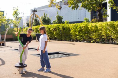 İki çocuk atlıkarıncada didişiyor ve yüksek sesle gülüyor, takılıyor, oyun alanında eğleniyor. Mutlu aktiviteler. Yüksek kalite fotoğraf