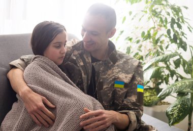 Ukrayna askeri üniformalı asker kızına sarılıyor. Aile toplantısı.