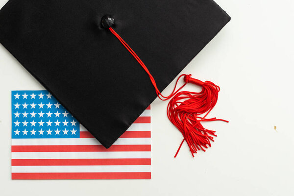 graduation hat on US flag, education concept. High quality photo