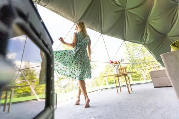 a woman enjoys solitude inside of a transparent bubble hotel