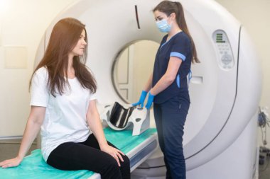 Radyolog, bilgisayarlı tomografi odasında bir kadın hasta ile birlikte..