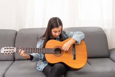 Güzel genç bir kız evde gitar çalar. Yüksek kalite fotoğraf