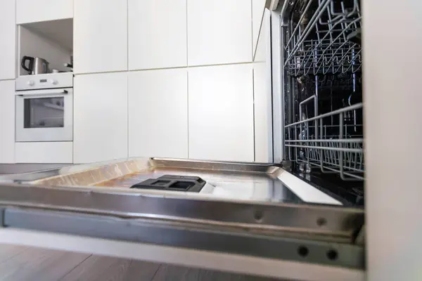 repair of a modern dishwasher with screwdrivers in the kitchen. High quality photo