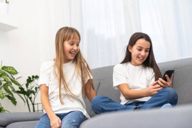 Çocuklar evde cep telefonuyla oynuyorlar. Yüksek kalite fotoğraf