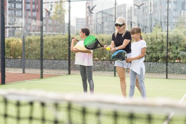 Anne ve kızları dışarıda Padel oynuyorlar. Yüksek kalite fotoğraf