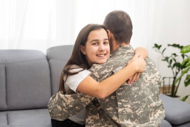 Askeri üniformalı genç bir adam ve karısı evdeki kanepede. Yüksek kalite fotoğraf