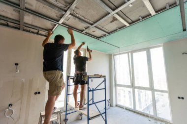 Adam alçı tavanlar için metal çerçeve monte ediyor. Yüksek kalite fotoğraf