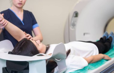 Radyolojik teknisyen ve hasta hastanedeki bilgisayarlı tomografi tarayıcısıyla taranıyor ve teşhis ediliyor..