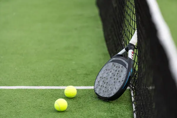 White professional paddle tennis racket with natural lighting on blue background. Horizontal sport theme poster, greeting cards, headers, website and app. High quality photo